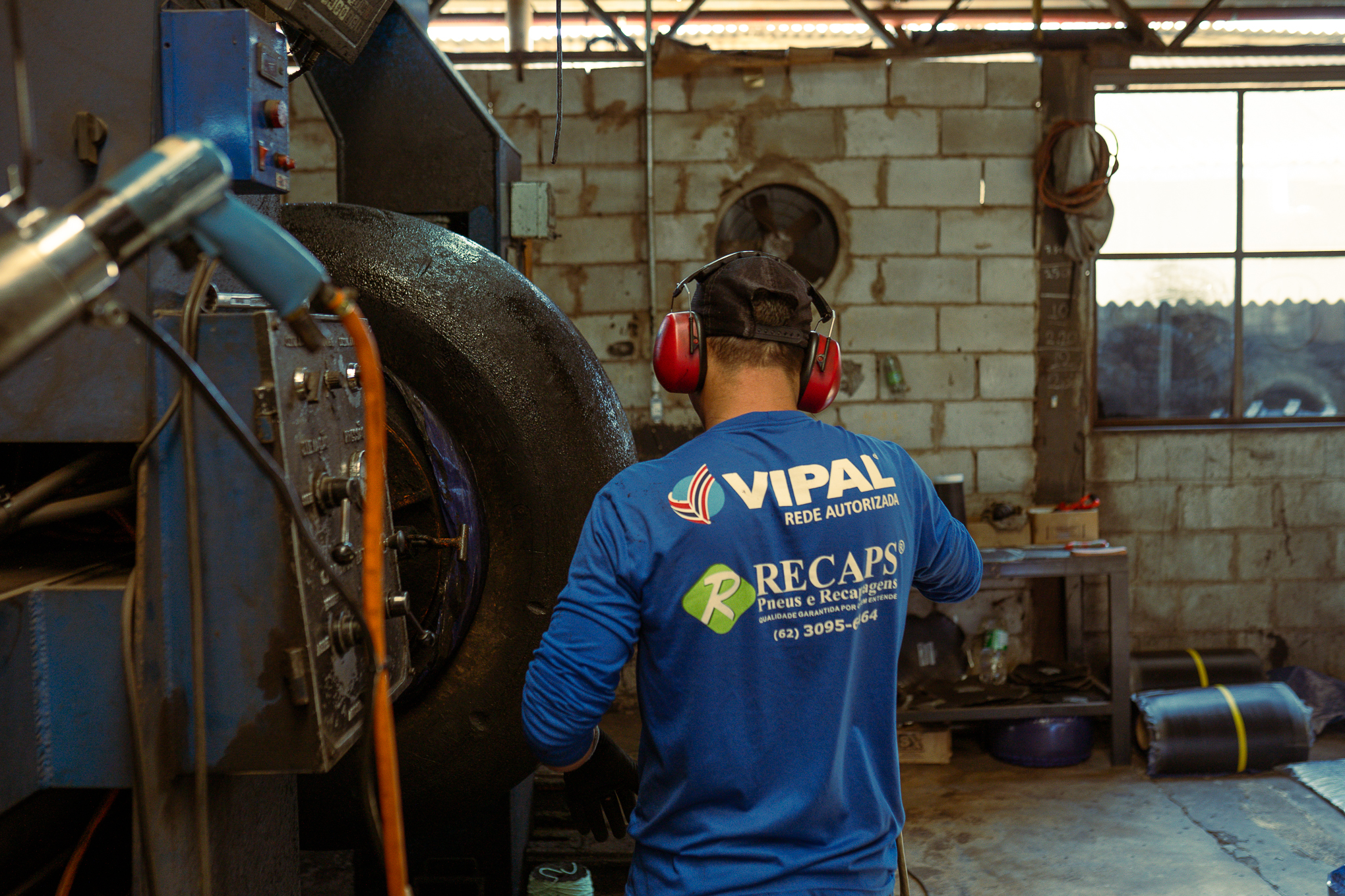 Foto de funcionário da RPS Pneus realizando recapagem.